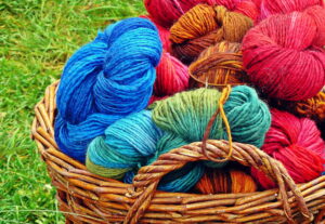 Different colored skeins of yarn in a basket